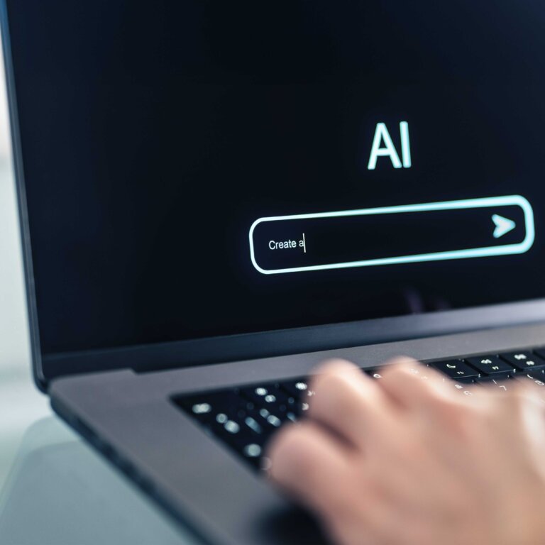  A person typing on a laptop with an AI search bar on the screen.