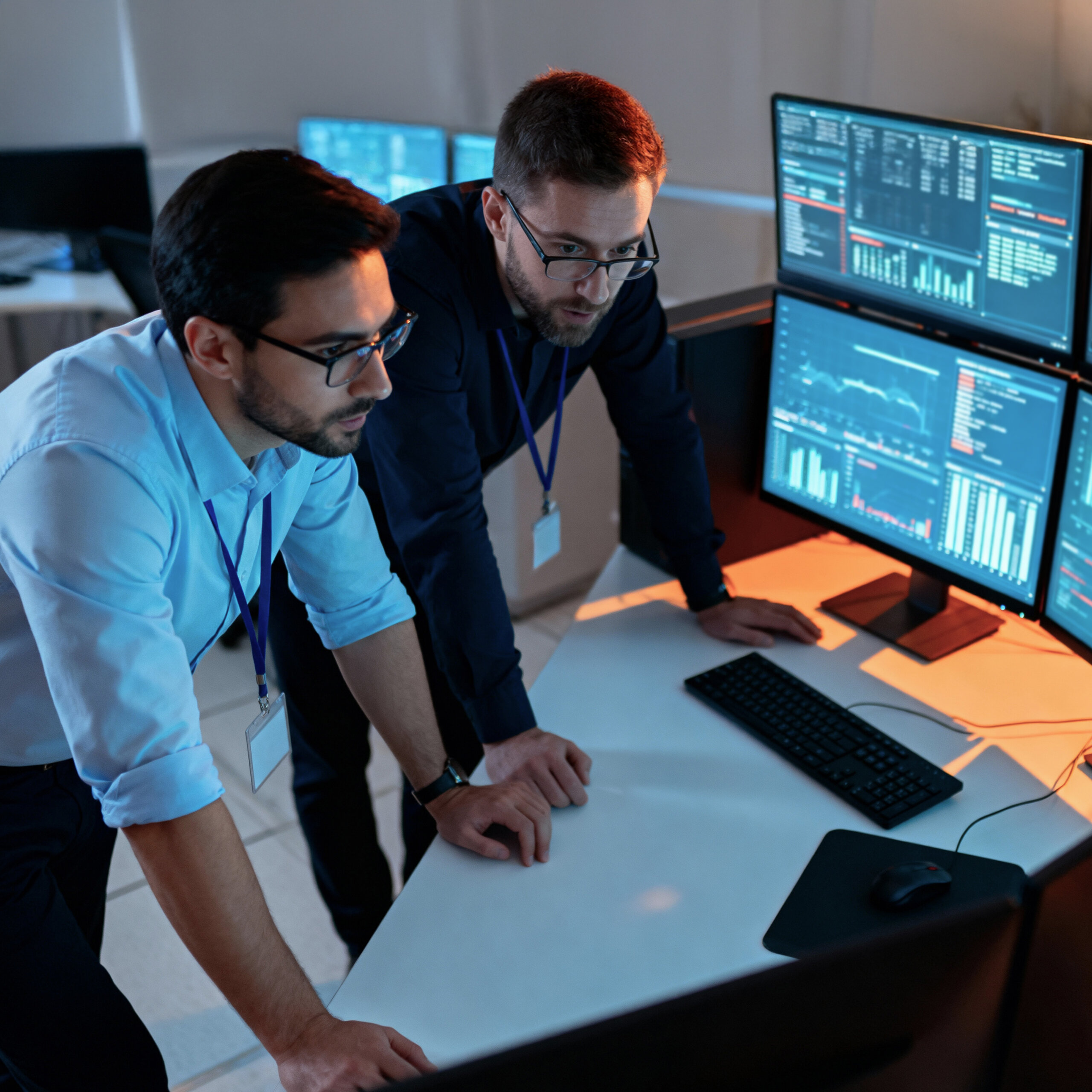 IT professionals analyzing real time data in a control room.